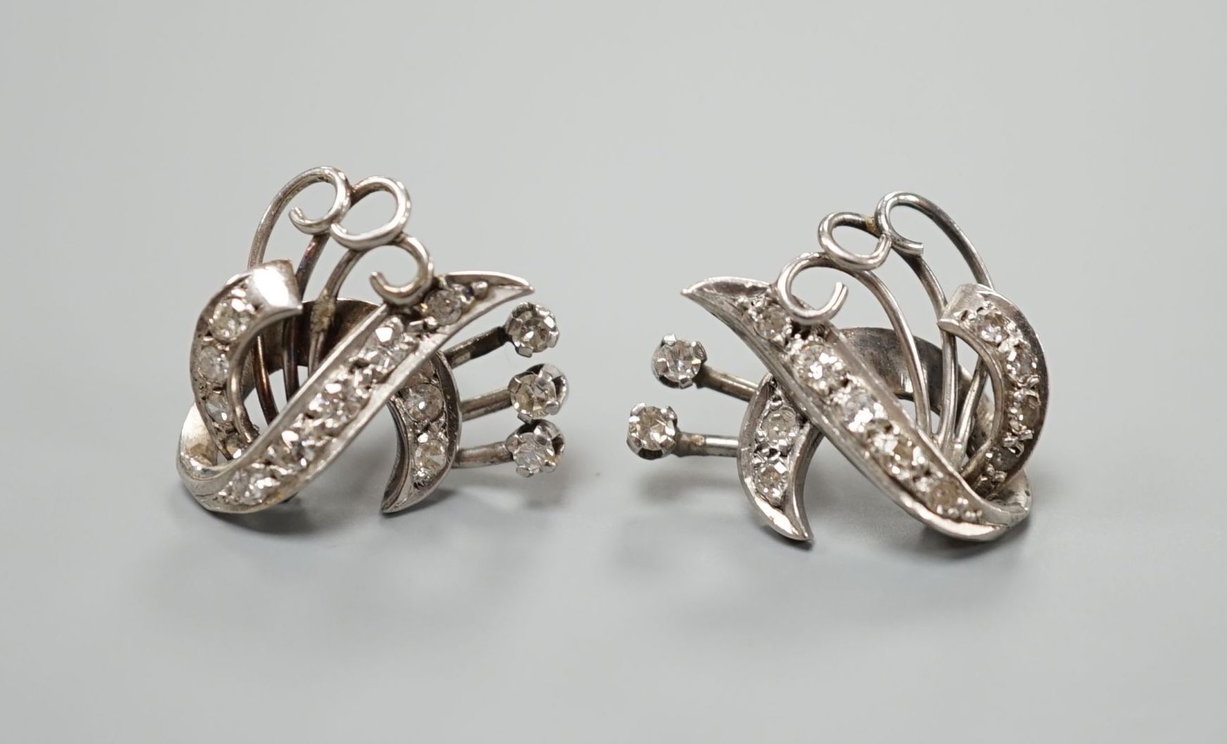 A pair of 20th century white metal and diamond cluster set fan scroll earrings(lacking butterflies), 15mm, gross weight 8 grams.